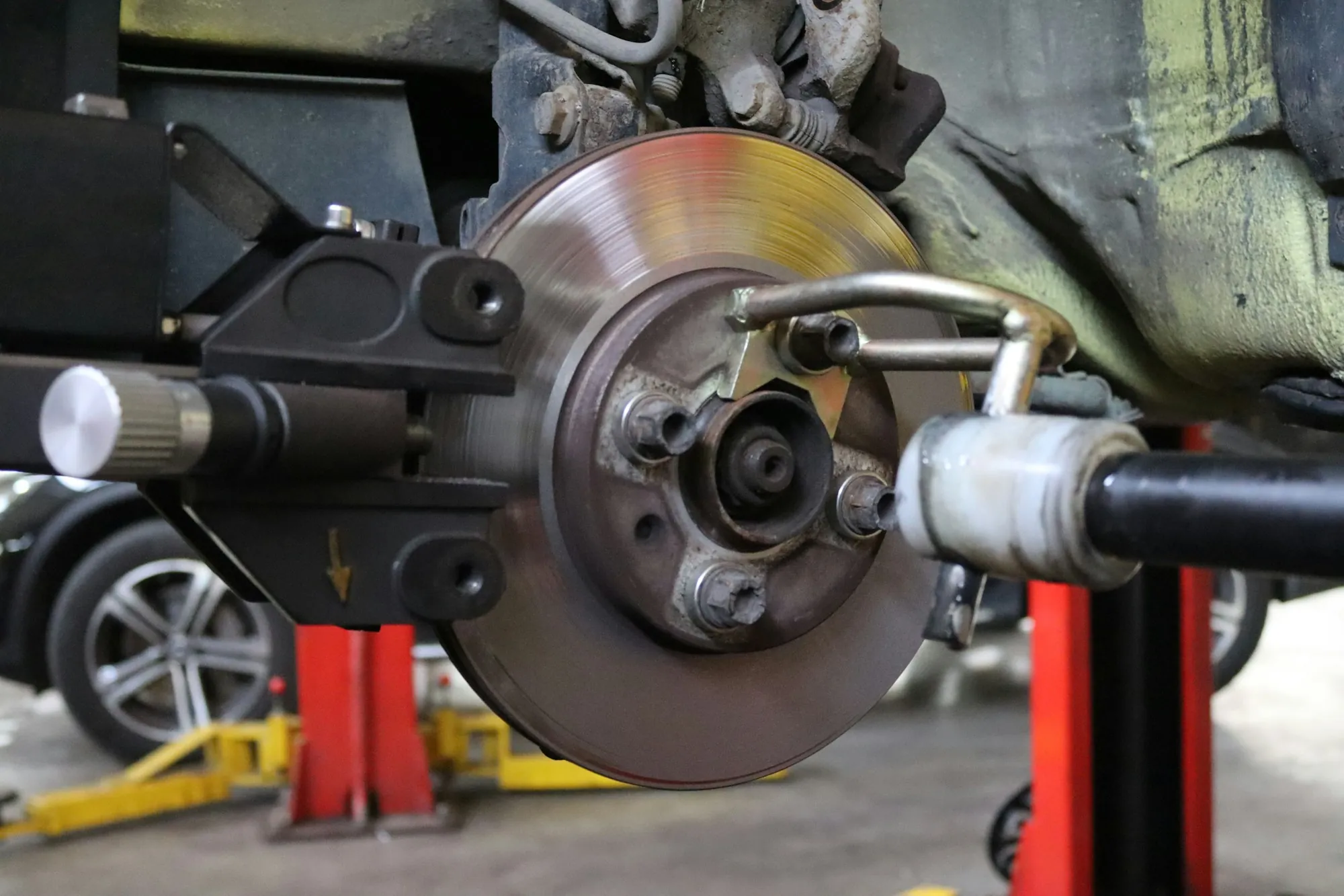 Brake rotor and caliper on a raised vehicle with the wheel off